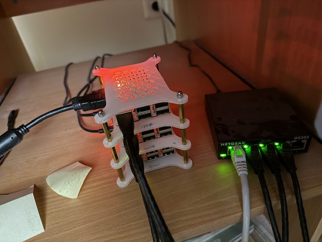 Photo of the Potatoes. There are 3 SBCs on a mini rack next to a Netgear router.